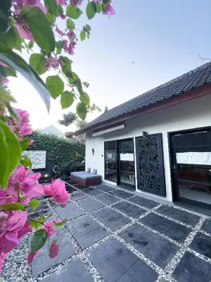a patio outside of a house with pink flowers at Ohara Hideway 3BR Japanese Vibes Villa in Kerobokan Seminyak Bali in Seminyak