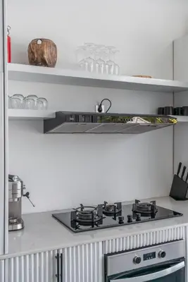 a stove top oven in a kitchen with shelves at Sandy Shores Villa 3 Modern 3BR Villa in Canggu in Canggu