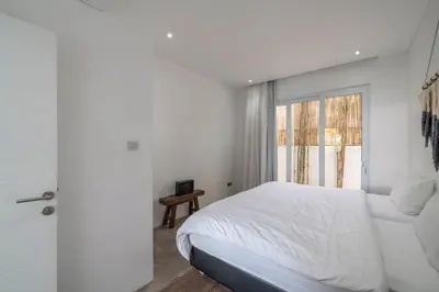 a white bedroom with a bed and a window at Sandy Shores Villa 3 Modern 3BR Villa in Canggu in Canggu