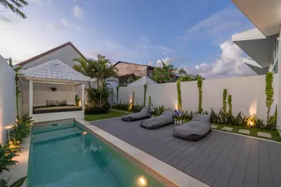 a swimming pool with pillows next to a house at Sandy Shores Villa 3 Modern 3BR Villa in Canggu in Canggu