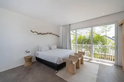 a bedroom with a bed and a large window at Sandy Shores Villa 3 Modern 3BR Villa in Canggu in Canggu