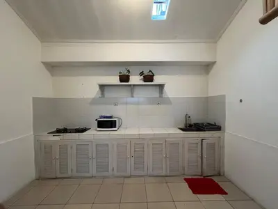 a kitchen with white cabinets and a microwave at Kondo Villa 2 BR- Private Pool in Seminyak