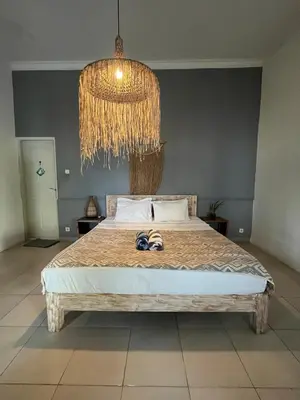 a bedroom with a bed with a chandelier and two shoes on it at Kondo Villa 2 BR- Private Pool in Seminyak