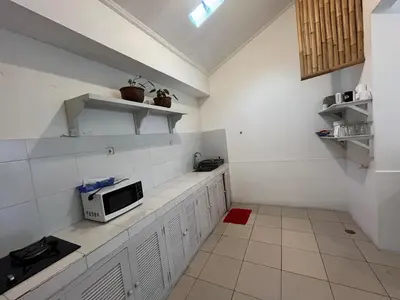 a kitchen with white cabinets and a microwave at Kondo Villa 2 BR- Private Pool in Seminyak