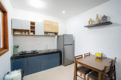 a kitchen with a table and a stainless steel refrigerator at Town House, Modern Minimalis, Lokasi Strategis in Seminyak
