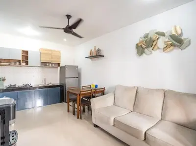 a living room with a couch and a kitchen at Town House, Modern Minimalis, Lokasi Strategis in Seminyak