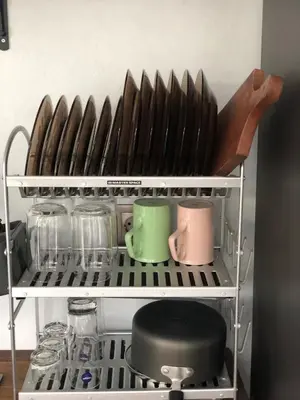 a shelf with dishes and utensils on it at Villa Denira, Home Gym & Private Pool in Nusa Dua