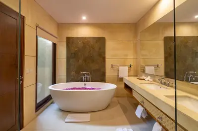 a bathroom with a large tub and two sinks at Aragreen Berawa Villa in Canggu
