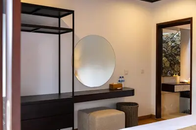 a dressing room with a mirror and a stool at Aragreen Berawa Villa in Canggu