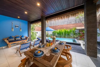 a dining room with a table and chairs and a pool at Villa De Ocean in Seminyak