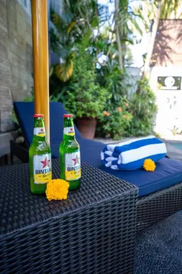 two bottles of beer sitting on a wicker table at Villa De Ocean in Seminyak