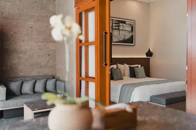 a hotel room with a bed and a couch at Dikubu Belong VILLA in Denpasar