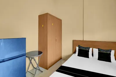 a bedroom with a bed and a cabinet and a table at Hotel O near Trans Studio Theme Park formerly Cyloam Residence in Legian