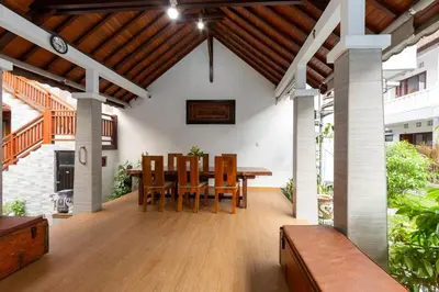 an outdoor dining room with a wooden table and chairs at Cove De Pavilla in Sanur