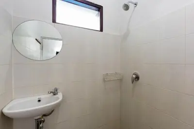 a white bathroom with a sink and a mirror at Cove De Pavilla in Sanur