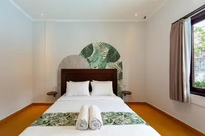 a bedroom with a bed with two towels on it at Cove De Pavilla in Sanur