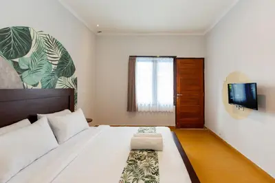 a bedroom with a bed and a tv on a wall at Cove De Pavilla in Sanur
