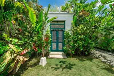 a blue door in the middle of a garden at LePalms villa, 2min Beach, 10min Atlas,Finns Club in Canggu