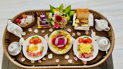 a table with plates of food and flowers on it at Seminyak Classic 1BRoom Private Pool Villa in Seminyak