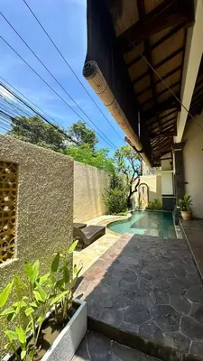 a house with a swimming pool next to a wall at Seminyak Classic 1BRoom Private Pool Villa in Seminyak