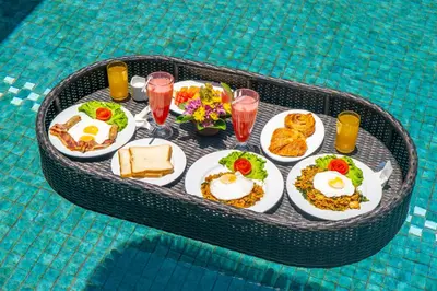 a tray of breakfast food on a table in a pool at Villa PBC 2 Bed Room Private Pool in Seminyak in Seminyak