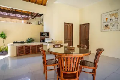 a kitchen with a wooden table and chairs at Clasic 3BRoom Villa In Seminyak in Seminyak