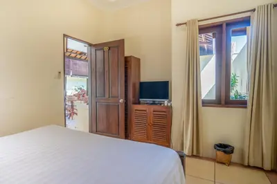 a bedroom with a bed and a tv and a window at Clasic 3BRoom Villa In Seminyak in Seminyak
