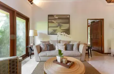 a living room with a couch and a table at Three Bedrooms Elegant Home The White Door Villa in Sanur