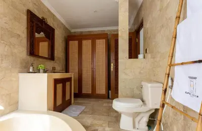 a bathroom with a toilet and a sink and a tub at Three Bedrooms Elegant Home The White Door Villa in Sanur