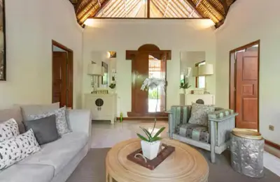 a living room with a couch and a table at Three Bedrooms Elegant Home The White Door Villa in Sanur
