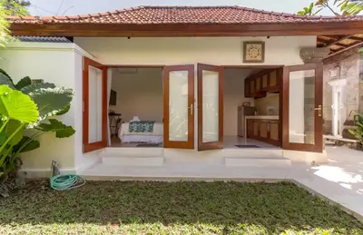 a small house with a patio with a clock at Three Bedrooms Elegant Home The White Door Villa in Sanur