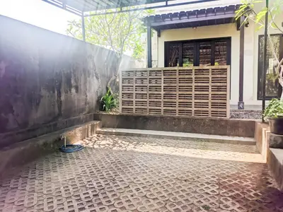 a house with a stone floor in front of a building at The Lavana Villa Singgahan Jimbaran - 3 Bedroom Villa in Nusa Dua