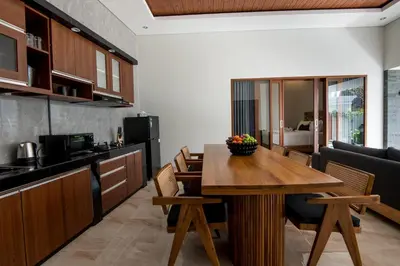 a kitchen and dining room with a wooden table at Villa Sakura ll seminyak in Seminyak