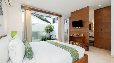 a bedroom with a white bed and a television at Villa Bidadari With Pool in Seminyak