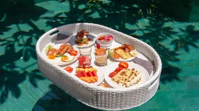 a table with plates of food on top of it at Villa Bidadari With Pool in Seminyak