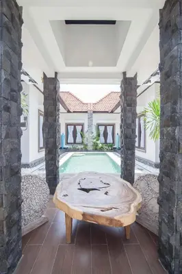a living room with a table and a swimming pool at Villa Marjens 2 Seminyak area Bali in Kerobokan