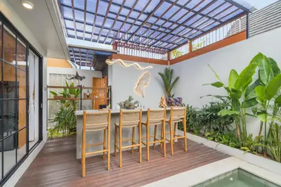 a balcony with a table and chairs and a pool at NaraDama Villa Seminyak Bali in Seminyak