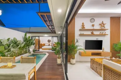 a living room with a swimming pool and a tv at NaraDama Villa Seminyak Bali in Seminyak