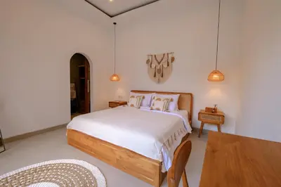 a bedroom with a bed and a table and chairs at New Vindra I Villa 2BR in the heart of Berawa in Canggu
