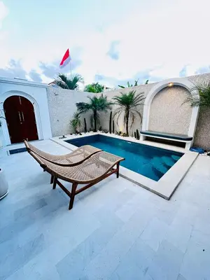 a patio with a hammock next to a swimming pool at New Vindra I Villa 2BR in the heart of Berawa in Canggu