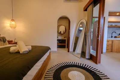 a bedroom with a bed and a bathroom at New Vindra I Villa 2BR in the heart of Berawa in Canggu