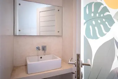 a bathroom with a white sink and a mirror at Villa Tara in Seminyak