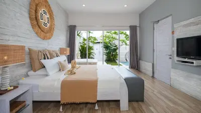a bedroom with a large bed and a couch at Villa Larimar by Villa Finder in Legian