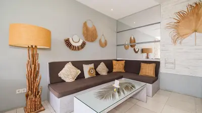 a living room with a couch and a table at Villa Larimar by Villa Finder in Legian
