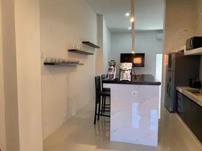 a kitchen with a counter with a bar in it at Klissy Studio Villa in Kerobokan