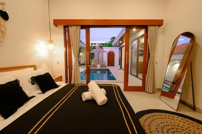 a bedroom with a large bed and a swimming pool at New Vindra II Villa Mediteranian 2BR Canggu in Canggu