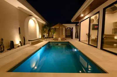 a swimming pool in a house at night at New Vindra II Villa Mediteranian 2BR Canggu in Canggu