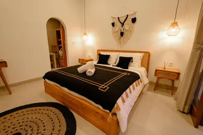 a bedroom with a large bed with black and white sheets at New Vindra II Villa Mediteranian 2BR Canggu in Canggu