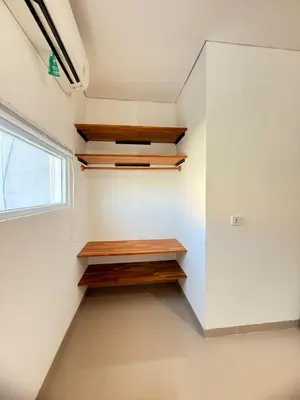 a walk in closet with wooden shelves and a window at Home Stay Room in Bali Near Sanur Beach in Sanur