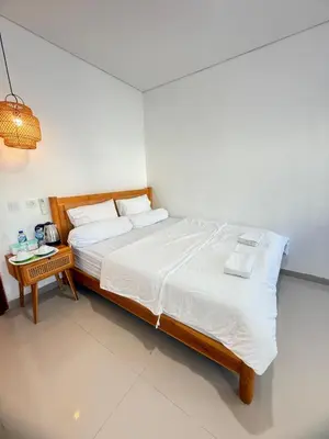a bedroom with a large bed and a table at Home Stay Room in Bali Near Sanur Beach in Sanur